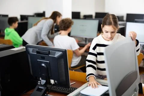 Schoolgirl using printer during computer science lesson 写真素材
