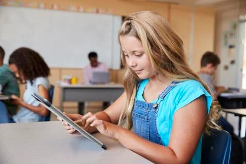 Schoolgirl using tablet in elementary school class, close up 写真素材