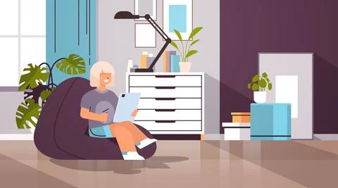 Schoolgirl using tablet pc happy girl sitting on beanbag and doing homework Stock Illustration