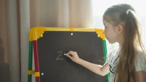 Schoolgirl writes mathematical problems on blackboard Stock Footage 247915014