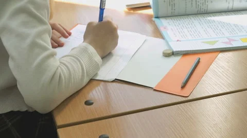 Schoolgirl writes the text in a copybook using pen Stock Footage 69001730