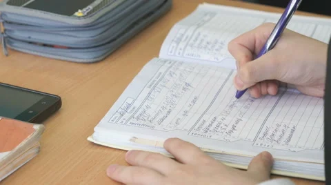 Schoolgirl writes the text in the school diary Stock Footage 68985905