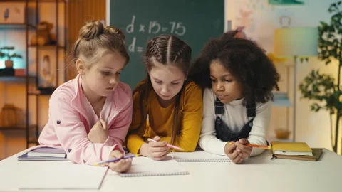 Schoolgirls focus on their homework in class, talking about the math problem 库存影片 298020110