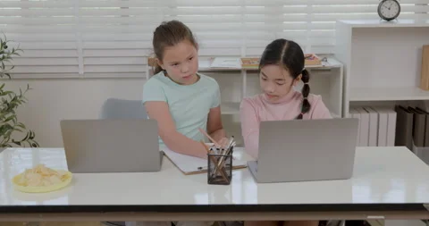 Schoolgirls Using Laptops And Writing Notes In Classroom Medium Shot Stock Footage 336248489