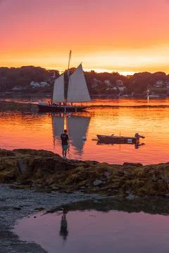 A schooner returns to dock at sunset at Bailey Island, Casco Bay, Maine, United Stock Photos