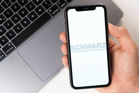 SCHWARZ mobile application on the smartphone screen. A mobile phone in a man 스톡 사진