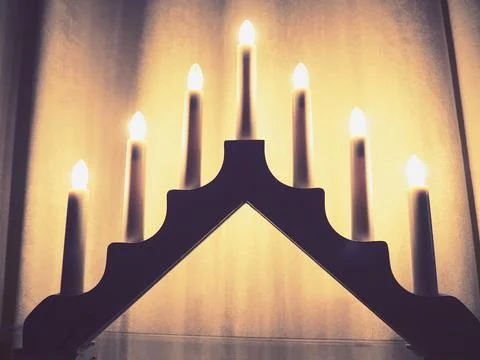 Schwibbogen arch luminaire in the form of a triangular candlestick. Yellow backg Stock Photos