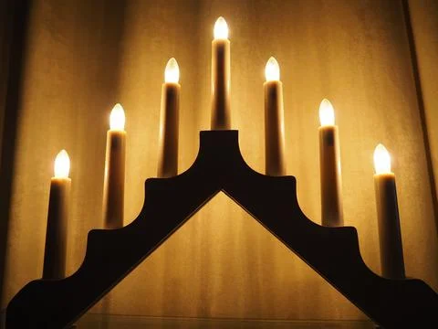 Schwibbogen arch luminaire in the form of a triangular candlestick. Yellow backg Stock Photos