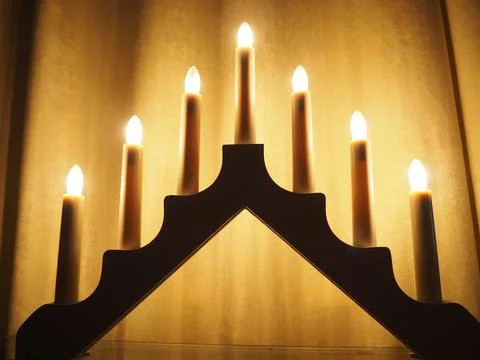 Schwibbogen arch luminaire in the form of a triangular candlestick. Yellow backg Stock Photos