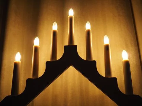 Schwibbogen arch luminaire in the form of a triangular candlestick. Yellow backg Stock Photos