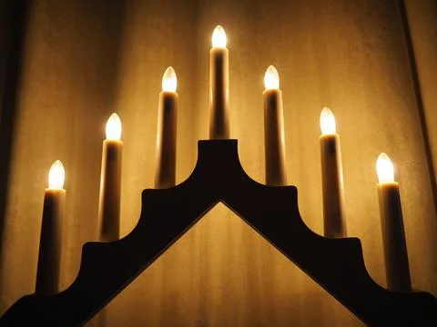 Schwibbogen arch luminaire in the form of a triangular candlestick. Yellow backg Stock Photos
