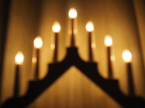 Schwibbogen arch luminaire in the form of a triangular candlestick. Yellow backg Stock Photos
