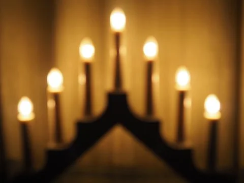 Schwibbogen arch luminaire in the form of a triangular candlestick. Yellow backg Stock Photos