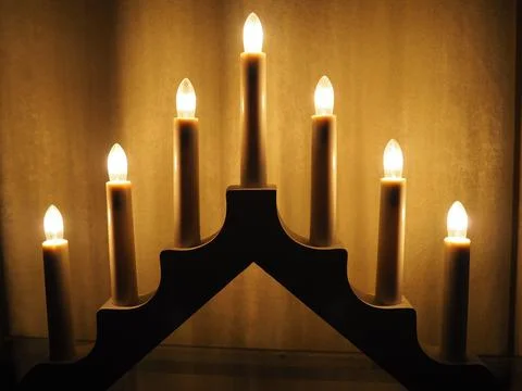 Schwibbogen arch luminaire in the form of a triangular candlestick. Yellow backg Stock Photos