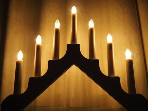 Schwibbogen arch luminaire in the form of a triangular candlestick. Yellow ba Stock Photos