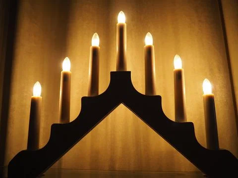 Schwibbogen arch luminaire in the form of a triangular candlestick. Yellow ba Stock Photos