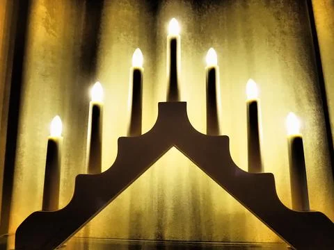 Schwibbogen arch luminaire in the form of a triangular candlestick. Yellow ba Stock Photos