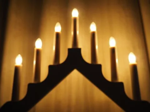 Schwibbogen arch luminaire in the form of a triangular candlestick. Yellow ba Stock Photos