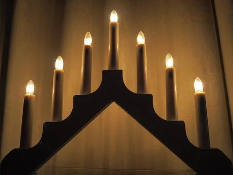 Schwibbogen arch luminaire in the form of a triangular candlestick. Yellow ba Stock Photos