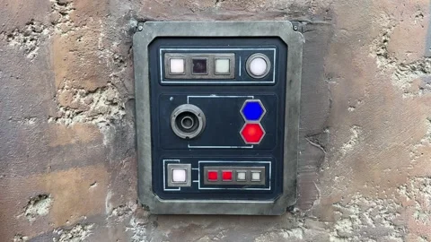Sci Fi Control Panel with Blue and Red Indicator Lights on Worn Concrete Wall Stock-Footage 346984934