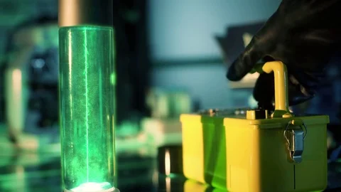 Sci-fi scientist picks up geiger counter and checks glowing fluid 4k Stock Footage 83960902
