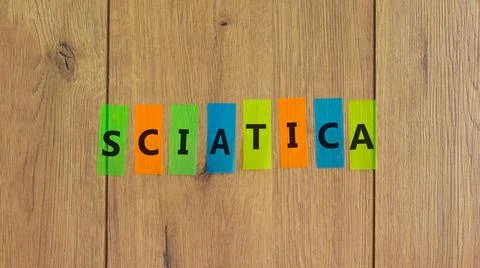Sciatica symbol. Concept word 'sciatica' on colored papers on a beautiful woo Stock Photos