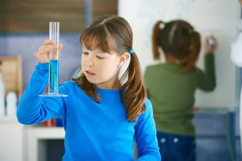 Science class at primary school Elementary age school girl looking at test... Stock Photos