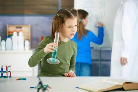 Science class at primary school Elementary age school girl looking at test... Stock Photos