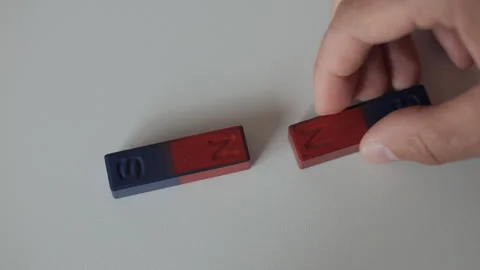 Science Educational Experiment With Magnets. Man Hand Moves Two Magnets Around Stock Footage 278445195