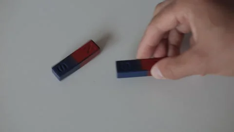 Science Educational Experiment With Magnets. Man Hand Moves Two Magnets Around Stock Footage 278570658