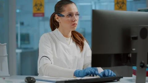 Science engineer working on computer and taking notes 스톡 사진