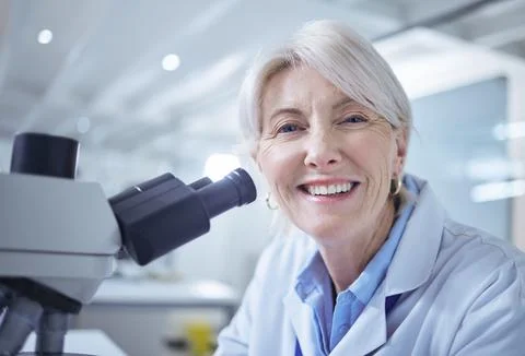 Science is an ever evolving field. a mature scientist using a microscope in her Stock Photos