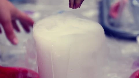 Science experiment with container releasing dense vapor and hands interacting Stock Footage 336468806