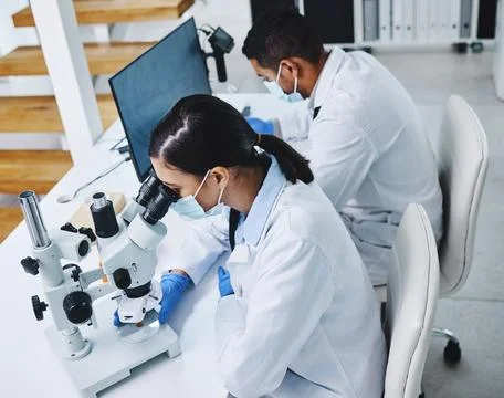 Science, laboratory and scientists with microscope and computer for research Stock Photos