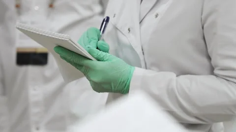 A science laboratory student writes down a lecture in a notebook. Stock Footage 294172429