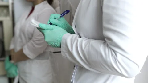 A science laboratory student writes down a lecture in a notebook. Stock Footage 294172511