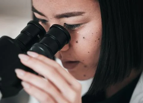 Science, microscope and closeup of Asian woman in laboratory for research Foto stock