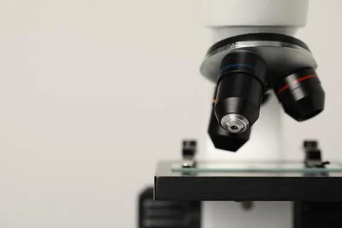 Science. Microscope with glass slide on light grey background, closeup. Spa.. Stock Photos