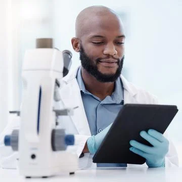 Science is organized knowledge. Shot ofa a young man using a tablet in a Stock Photos