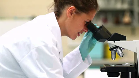 Science student looking through microscope Stock Footage 32881144
