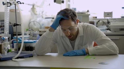 Science student or young scientist is tired and exhausted while sitting in a lab Stock Footage 112598545