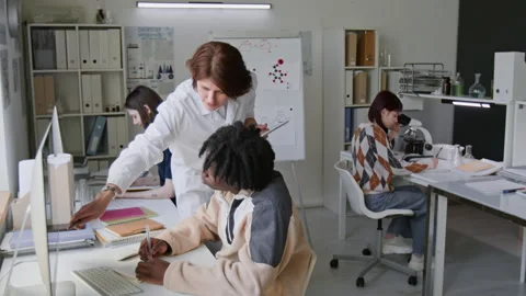 Science Teacher in Lab Coat Helping her Students During Chemistry Class in Lab Stock Footage 312322572