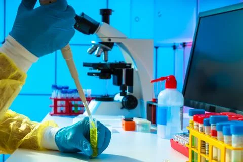 Scientific experiment in microbiological lab. Microscope and test tube 스톡 사진