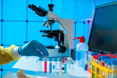 Scientific experiment in microbiological lab. Microscope and test tube 스톡 사진