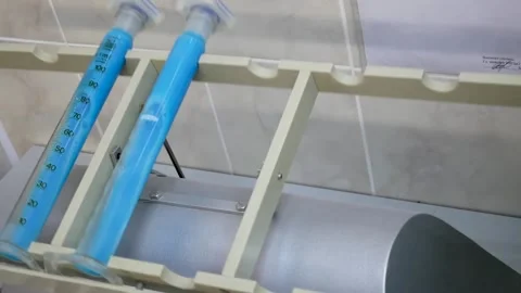 In a scientific laboratory, a machine with blue ampoules is operating. Stock Footage 130896647