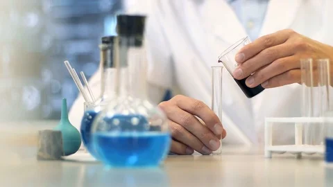 Scientific laboratory researcher performs tests with blue liquid. Close up Vidéo 74935507