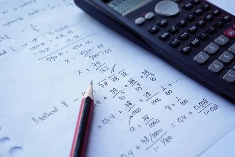 Scientific math workout. sheet paper with solving equation math next to calcu Stock Photos