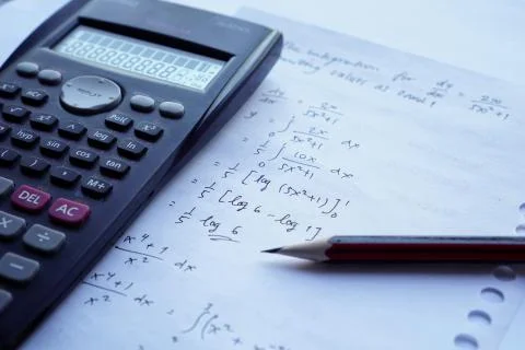 Scientific math workout. sheet paper with solving equation math next to calcu Stock Photos