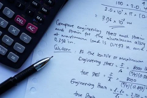 Scientific math workout. sheet paper with solving equation math next to calcu Stock Photos