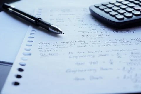 Scientific math workout. sheet paper with solving equation math next to calcu Stock Photos